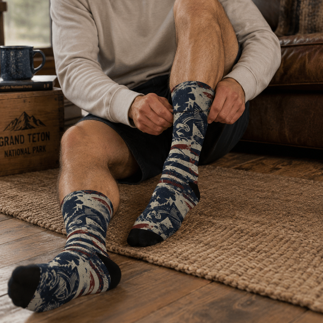 Man sitting on a couch wearing patterned socks in a cozy indoor setting.