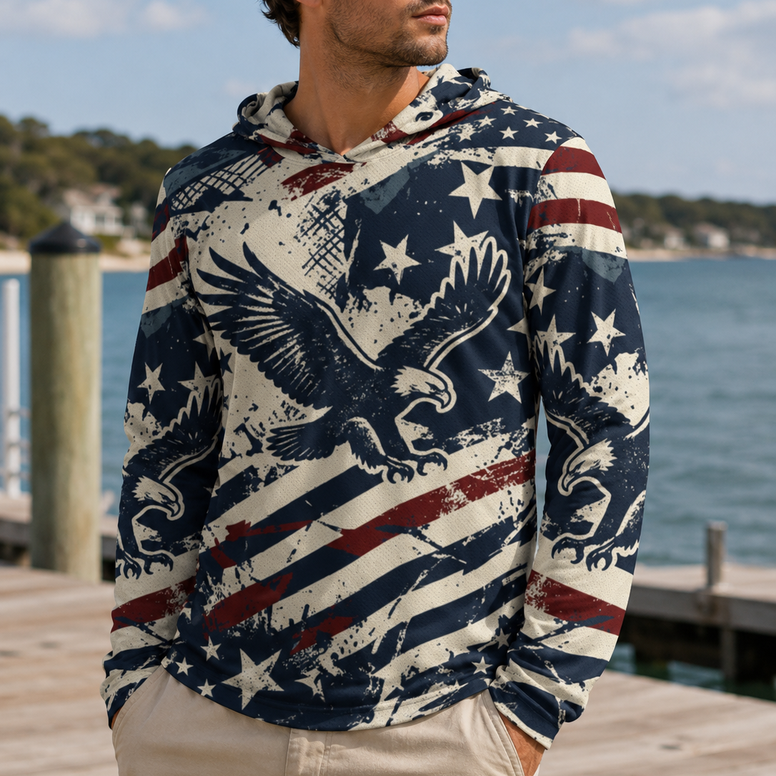 Man wearing a patriotic hoodie with an eagle design by a waterfront.