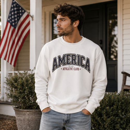 Man wearing a white sweatshirt with 'AMERICA ATHLETIC CLUB' text on a porch with an American flag.