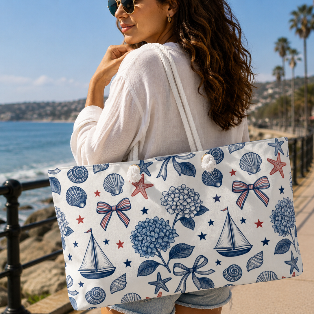 Woman holding a tote bag with floral and nautical patterns by the beach.